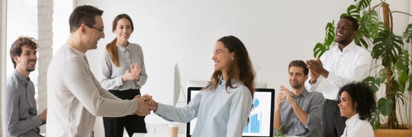 Boss welcoming new employee hired intern female, mixed race woman feel happy promoted receive appreciation for good work result from company head colleagues applauding banner for website header design