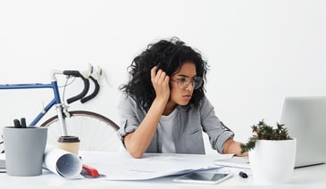 Shot of tired business enterpreneur dark-skinned female wearing big eyeglasses being worried